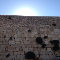View of Kotel with sun above the bricks