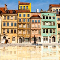 Morning in Warsaw Poland. A block of multi-level apartment buildings with red roofs set against a blue sky